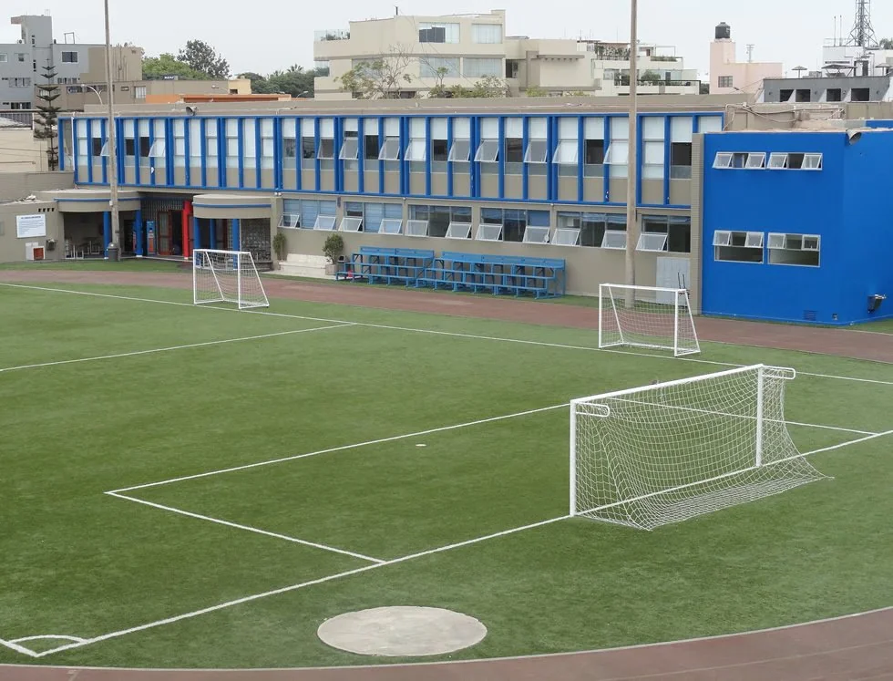 Cancha de fútbol y pabellón de aulas de un colegio