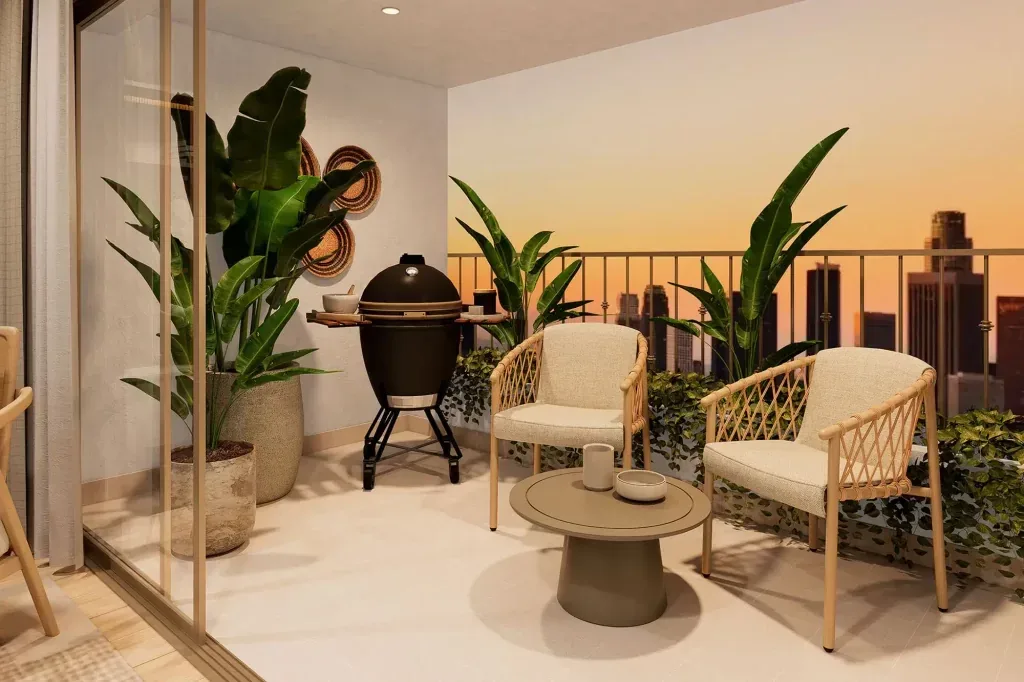 Terraza de un departamento de Beca Inmobiliaria con parrilla, sillones y vista a la ciudad al atardecer